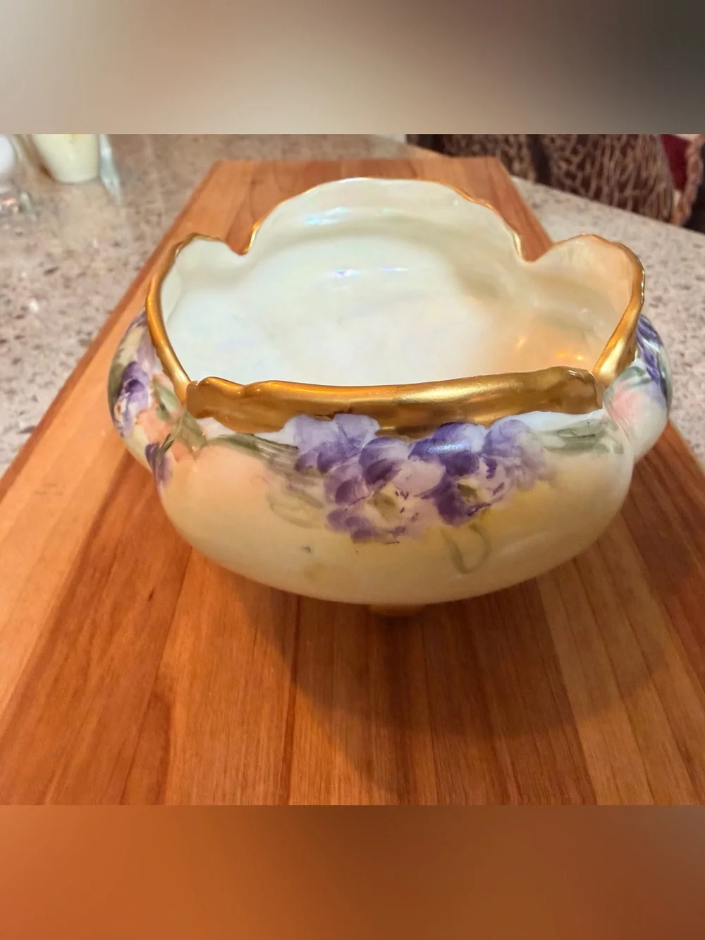 A hand-painted porcelain footed bowl with gilded rim and floral decoration.